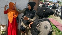 Salah satu pedagang menghadang personel Satpol PP yang akan melakukan penertiban dan pembongkaran lapak.