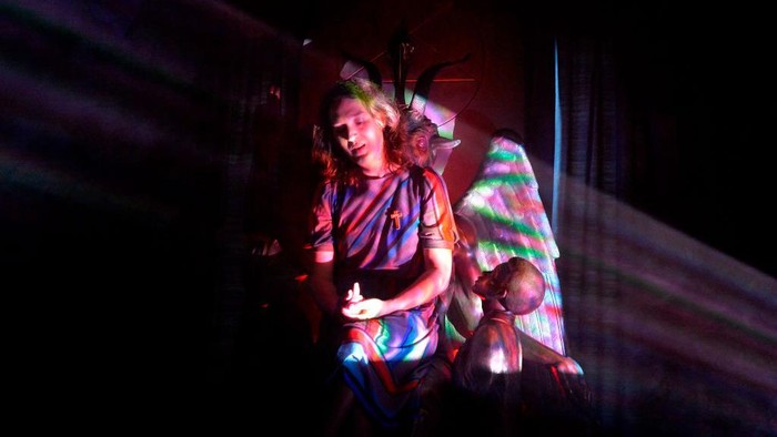 Mengintip Markas Pemuja Setan di AS TOPSHOT - Joy Davenport, sits on the statue of the Baphomet, at the Satanic Temple where a