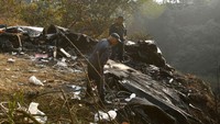 Badan pesawat Yeti Airlines yang jatuh di Nepal terbelah. Satu bagian berada di lereng bukit, bagian lain jatuh ke ngarai sungai. Prakash Mathema/AFP/Getty Images  