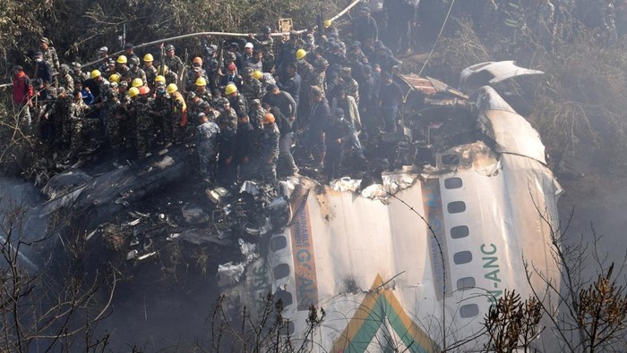 Penampakan Puing-puing Pesawat Jatuh di Nepal yang Tewaskan Puluhan Orang Rescue teams work to retrieve bodies from the wreckage at the crash site of an aircraft carrying 72 people in Pokhara in western Nepal January 15, 2023. REUTERS/Krishna Mani Baral NO RESALES. NO ARCHIVES