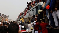 Warga bahu membantu agar penumpang bisa naik ke atap kereta.