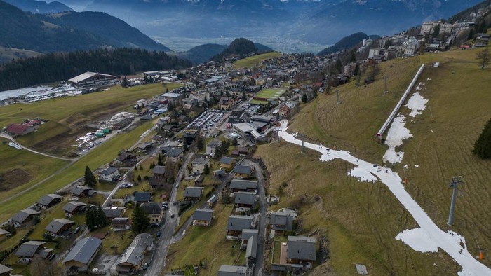 Potret Resor Ski di Swiss Kehilangan Salju Akibat Perubahan Iklim Skiers pass on a small layer of artificial snow amid warmer-than-usual winter temperatures in the Alps in Leysin, Switzerland, January 4, 2023. REUTERS/Denis Balibouse TPX IMAGES OF THE DAY