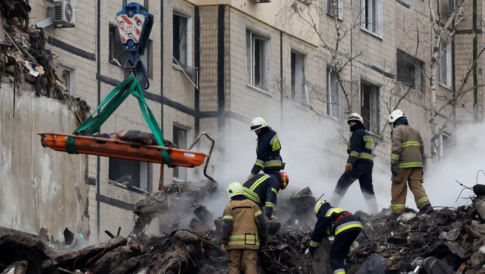 Sedih! Begini Proses Evakuasi Korban Serangan Rusia di Dnipro Emergency personnel work at the site where an apartment block was heavily damaged by a Russian missile strike, amid Russia's attack on Ukraine, in Dnipro, Ukraine January 15, 2023. REUTERS/Clodagh Kilcoyne TPX IMAGES OF THE DAY