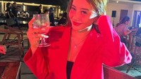 Sesekali ia juga tampak lebih formal saat bersantai di beach club. Mengenakan blazer berwarna merah, Sevira menikmati cocktail dengan gaya yang anggun. Foto: Instagram/svra30_
