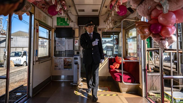 Siasat Kereta di Pedesaan Jepang yang Mulai Ditinggal Penumpang This picture taken on October 20, 2022 shows a train travelling through Choshi Electric Railway Line in Choshi, northeast Chiba prefecture. - In the driver's seat of a two-carriage train, Katsunori Takemoto puts on his white gloves and checks the antiquated gauges before setting out alongside cabbage fields in Japan's rural Chiba. Like many small railway lines across Japan's countryside, the 60-year-old trains that ply this route are a loss-maker, but Takemoto has found a way to keep the business afloat. - TO GO WITH Japan-transport-demographics-economy,FOCUS by Hiroshi HIYAMA (Photo by Philip FONG / AFP) / TO GO WITH Japan-transport-demographics-economy,FOCUS by Hiroshi HIYAMA (Photo by PHILIP FONG/AFP via Getty Images)