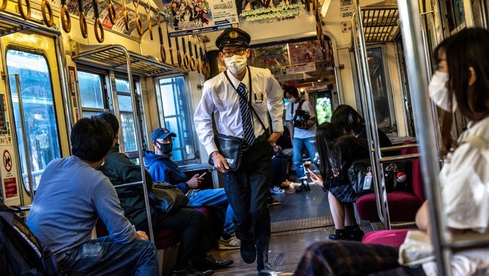 This picture taken on October 20, 2022 shows a train travelling through Choshi Electric Railway Line in Choshi, northeast Chiba prefecture. - In the drivers seat of a two-carriage train, Katsunori Takemoto puts on his white gloves and checks the antiquated gauges before setting out alongside cabbage fields in Japans rural Chiba. Like many small railway lines across Japans countryside, the 60-year-old trains that ply this route are a loss-maker, but Takemoto has found a way to keep the business afloat. - TO GO WITH Japan-transport-demographics-economy,FOCUS by Hiroshi HIYAMA (Photo by Philip FONG / AFP) / TO GO WITH Japan-transport-demographics-economy,FOCUS by Hiroshi HIYAMA (Photo by PHILIP FONG/AFP via Getty Images)