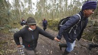 Orang-orang berlari saat latihan evakuasi di lereng Gunung Berapi Cotopaxi di Ticatilin, Ekuador, Minggu (15/1/2023).  