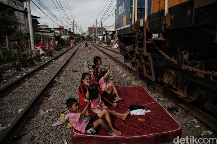 Sejumlah warga beraktivitas di kawasan permukiman padat pinggir rel kereta api, Kampung Muka, Pademangan, Jakarta Utara, Senin (16/1/2023).