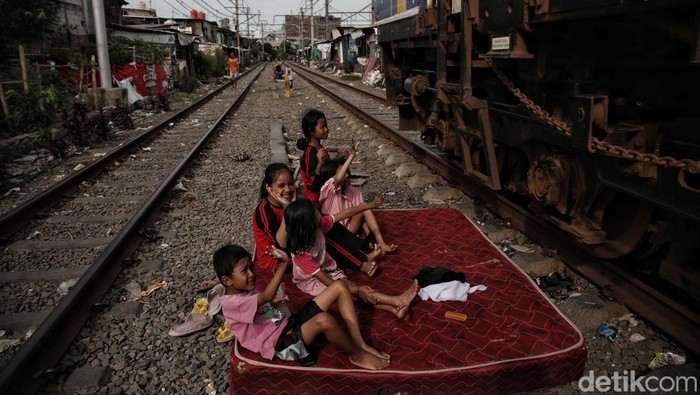 Sejumlah warga beraktivitas di kawasan permukiman padat pinggir rel kereta api, Kampung Muka, Pademangan, Jakarta Utara, Senin (16/1/2023).