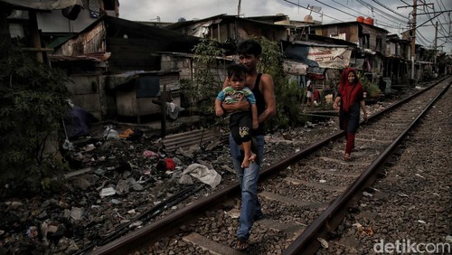 Sejumlah warga beraktivitas di kawasan permukiman padat pinggir rel kereta api, Kampung Muka, Pademangan, Jakarta Utara, Senin (16/1/2023).