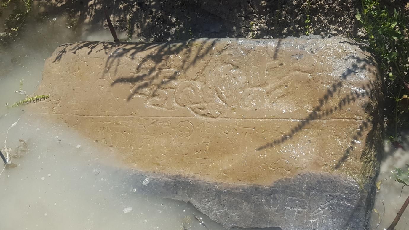 Bagian sudut temuan peneliti yang mengungkap inskripsi dari peradaban Raja Hartapu. Sebagian temuan ini terendam di saluran irigasi petani.