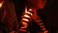 Orang-orang menyalakan lilin untuk mengenang korban kecelakaan pesawat yang dioperasikan oleh Yeti Airlines.