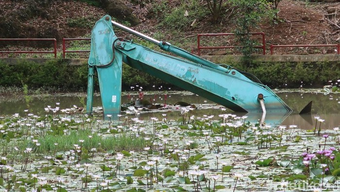Satu unit eskavator yang terjebak di danau buatan atau area 2 Kebun Buah Mangunan, Kabupaten Bantul. Selasa (17/1/2022). Penampakan eskavator yang bertahun-tahun terjebak di danau buatan Kebun Buah Mangunan. Saat ini eskavator itu hanya tampak pada bagian pengeruk saja