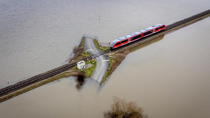 Kereta 'Belah' Banjir di Jerman Banjir merendam kawasan Nidderau-Eichen, Frankfurt, Jerman, Senin (16/1/2023) waktu setempat. Namun sebuah kereta api tetap beroperasi meski kanan-kiri perlintasan terendam banjir.
