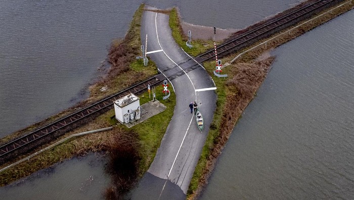 Banjir merendam kawasan Nidderau-Eichen, Frankfurt, Jerman, Senin (16/1/2023) waktu setempat. Namun sebuah kereta api tetap beroperasi meski kanan-kiri perlintasan terendam banjir.