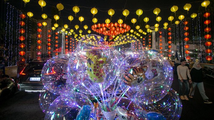 Warga berjalan-jalan di kawasan Pasar Gede yang dihiasi dengan lampion, di Solo, Jawa Tengah, Senin (16/1/2023). Panitia Imlek Solo memasang ribuan lampion di kawasan Pasar Gede untuk memeriahkan Tahun Baru Imlek dan sebagai daya tarik bagi wisatawan yang berkunjung ke Kota Solo. ANTARA FOTO/Mohammad Ayudha/tom.