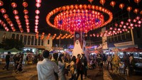 Warga berjalan-jalan di kawasan Pasar Gede yang dihiasi dengan lampion, di Solo, Jawa Tengah, Senin (16/1/2023) malam.