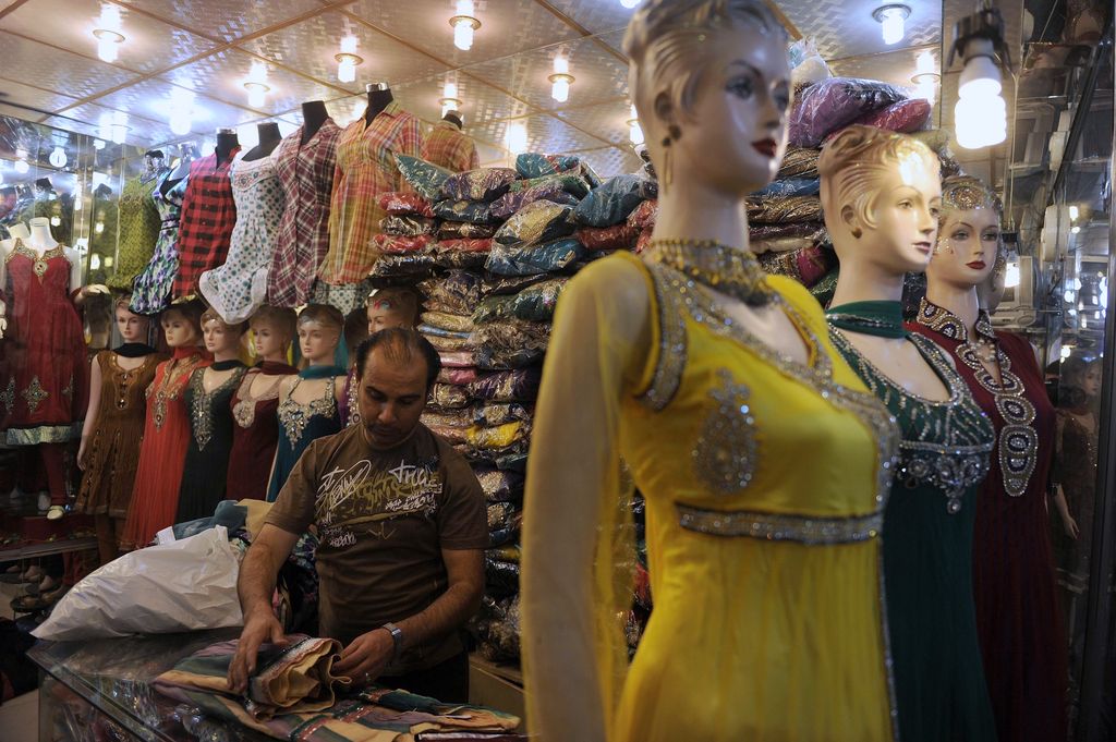 Afganistán-US-War-Anniversary-To-Go-with-Yuppies-Un comerciante afgano repara ropa india en exhibición en una tienda en Kabul en esta foto del 27 de septiembre de 2011 de Usman Sharifi. 