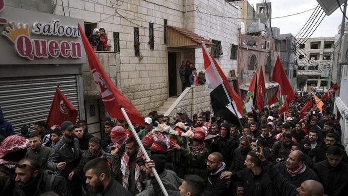 Omar Khmour, Bocah Palestina yang Tewas Ditembak Pasukan Israel Mourners carry the body of 14-year-old Palestinian Omar Khumour during his funeral in the West Bank city of Bethlehem, Monday, Jan. 16, 2023. The Palestinian Health Ministry said Khumour died after being struck in the head by a bullet during an Israeli military raid into Dheisha refugee camp near the city of Bethlehem. The Israeli army said that forces entered the Dheisha camp and were bombarded by Molotov cocktails and rocks. It said soldiers responded to the onslaught with live fire. (AP Photo/Mahmoud Illean)