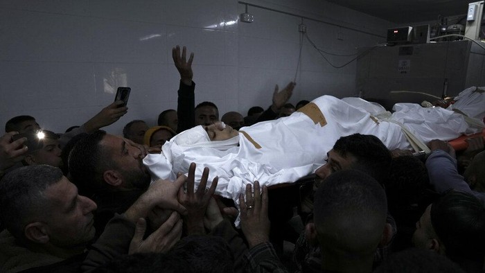 Mourners carry the body of 14-year-old Palestinian Omar Khumour during his funeral in the West Bank city of Bethlehem, Monday, Jan. 16, 2023. The Palestinian Health Ministry said Khumour died after being struck in the head by a bullet during an Israeli military raid into Dheisha refugee camp near the city of Bethlehem. The Israeli army said that forces entered the Dheisha camp and were bombarded by Molotov cocktails and rocks. It said soldiers responded to the onslaught with live fire. (AP Photo/Mahmoud Illean)