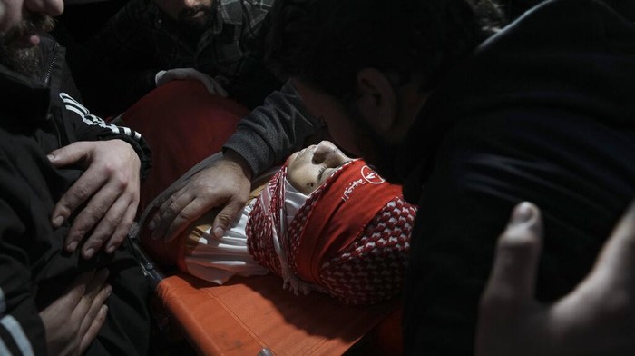 Omar Khmour, Bocah Palestina yang Tewas Ditembak Pasukan Israel Mourners carry the body of 14-year-old Palestinian Omar Khumour during his funeral in the West Bank city of Bethlehem, Monday, Jan. 16, 2023. The Palestinian Health Ministry said Khumour died after being struck in the head by a bullet during an Israeli military raid into Dheisha refugee camp near the city of Bethlehem. The Israeli army said that forces entered the Dheisha camp and were bombarded by Molotov cocktails and rocks. It said soldiers responded to the onslaught with live fire. (AP Photo/Mahmoud Illean)