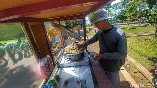 Pedagang Baso Tahu, Endang Mina Supriadi (54) memperlihatkan makanannya yang dibeli oleh tentara Amerika, di depan Koperasi Markas Yonif Para Raider 330/Tridharma, Kecamatan Cicalengka, Kabupaten Bandung.