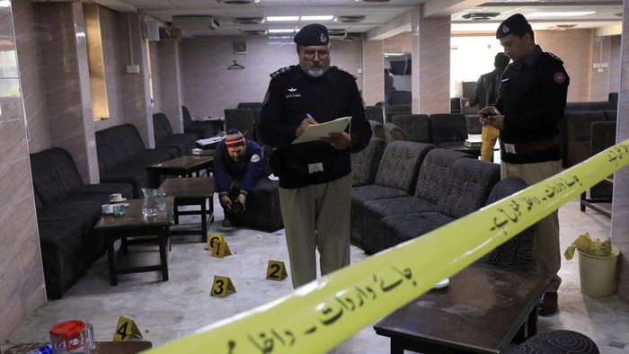 Police officers survey the crime scene following the shooting at Pakistans High Court that resulted in the death of prominent lawyer Abdul Latif Afridi. (Fayaz Aziz/Reuters)