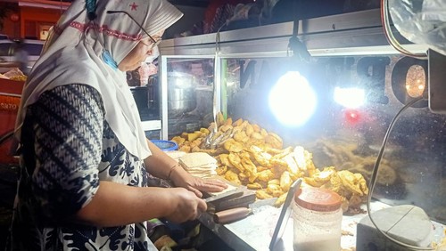Salah satu penjual gorengan di Jalan Rijasa, Kreneng, Denpasar, Bali, Ida Kusuma Wati (50) tengah menyiapkan gorengan di gerobaknya, Selasa (17/1/2023) malam. (Ni Made Lastri Karsiani Putri-detikBali)