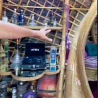 Di salah satu sisi toilet terdapat lemari pajangan yang terbuat dari kayu. Lemari pajangan tersebut berisi turntable atau pemutar piringan hitam, shisha, dan beberapa botol lainnya. Foto: TikTok/@traveltomtom