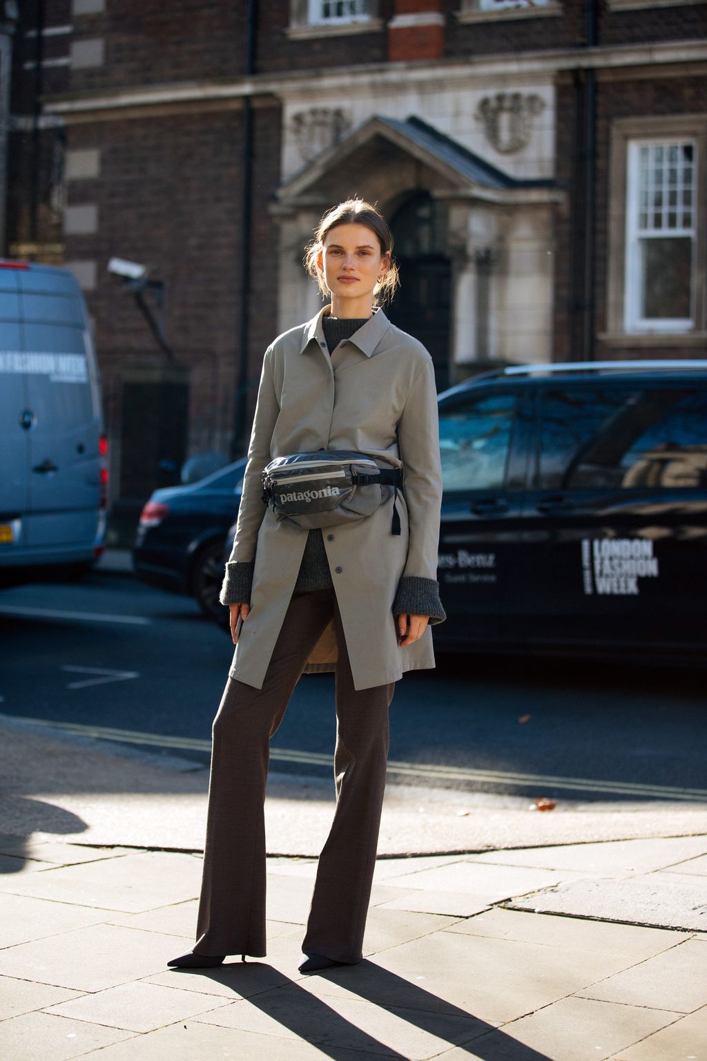 LONDON, ENGLAND - FEBRUARY 17: Model Giedre Dukauskaite wears a gray jacket, Patagonia fanny pack,, and brown trousers after Victoria Beckham during London Fashion Week February 2019 on February 17, 2019 in London, England. (Photo by Melodie Jeng/Getty Images)