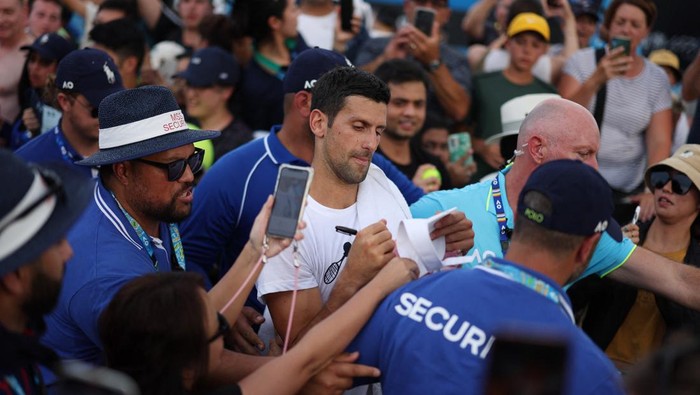 Berburu Tanda Tangan Petenis Dunia di Australia Open 2023 Tennis - Australian Open - Melbourne Park, Melbourne, Australia - January 17, 2023 Serbia's Novak Djokovic signs autographs for fans after a training session REUTERS/Loren Elliott