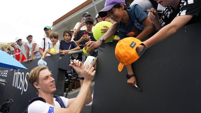 Denis Shapovalov of Canada signs autographs following his first round win over Dusan Lajovic of Serbia at the Australian Open tennis championship in Melbourne, Australia, Monday, Jan. 16, 2023. (AP Photo/Ng Han Guan)