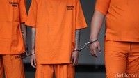 Para tersangka dihadirkan dalam pemusnahan barang bukti dengan tangan diborgol. Mereka juga mendapat penjagaan ketat petugas bersenjata.