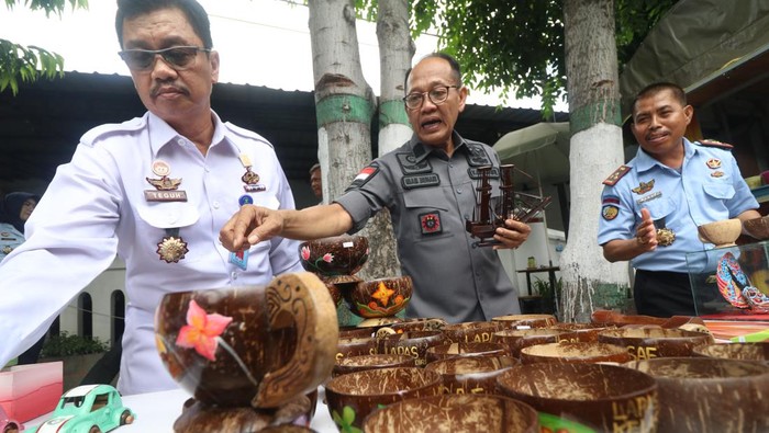 Kerajinan Cangkir Batok Kelapa Buatan Narapidana di Lapas Kediri Kakanwil Kemenkumham Jatim Imam Jauhari (tengah) didampingi Kepala Lembaga Pemasyarakatan (Lapas) Kelas 2A Kediri Muhammad Hanafi (kanan) meninjau kerajinan cangkir berbahan baku batok kelapa karya narapidana di Lapas Kota Kediri, Jawa Timur, Rabu (18/1/2023). Narapidana yang telah memasuki masa asimilasi di lapas tersebut diberikan sejumlah pelatihan keterampilan sebagai bekal hidup mandiri saat kelak kembali ke tengah masyarakat. ANTARA FOTO/Prasetia Fauzani/tom.