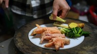 Seorang koki tengah menyiapkan ceker ayam Dong Tao untuk dihidangkan kepada pelanggan di sebuah restoran mewah di Hanoi.