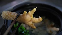 Pelanggan menunjukkan kaki ayam Dong Tao yang sudah dimasak dengan sumpit di sebuah restoran mewah di Hanoi. Untuk sepasang ayam Dong Tao bisa dibanderol USD 2.500 atau setara dengan Rp30 jutaan.