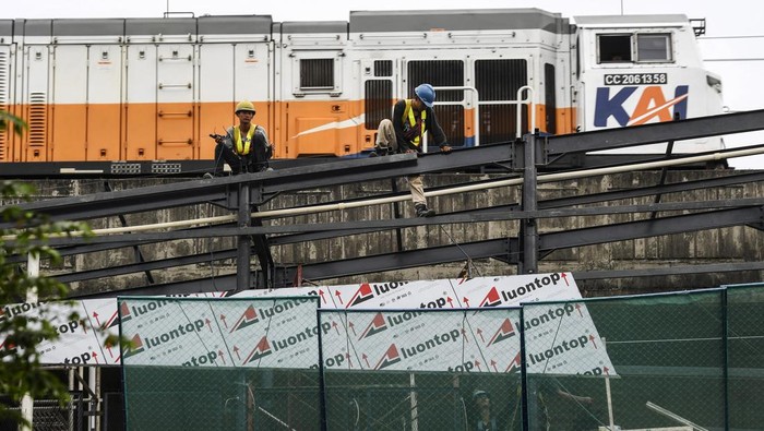 Pekerja menyelesaikan konstruksi jembatan penyeberangan dari Halte Transjakarta Juanda menuju Stasiun Kereta Api Juanda pada proyek revitalisasi Halte Transjakarta Juanda di Jakarta, Selasa (17/1/2023). PT Transjakarta merevitalisasi 46 halte yang empat diantaranya akan terintegrasi dengan stasiun kereta api sehingga dapat memudahkan penumpang untuk mengkases moda transportasi umum lanjutan. ANTARA FOTO/Hafidz Mubarak A/nym.