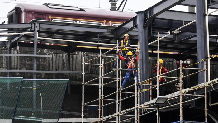 Pekerja menyelesaikan konstruksi jembatan penyeberangan dari Halte Transjakarta Juanda menuju Stasiun Kereta Api Juanda pada proyek revitalisasi Halte Transjakarta Juanda di Jakarta, Selasa (17/1/2023). PT Transjakarta merevitalisasi 46 halte yang empat diantaranya akan terintegrasi dengan stasiun kereta api sehingga dapat memudahkan penumpang untuk mengkases moda transportasi umum lanjutan. ANTARA FOTO/Hafidz Mubarak A/nym.