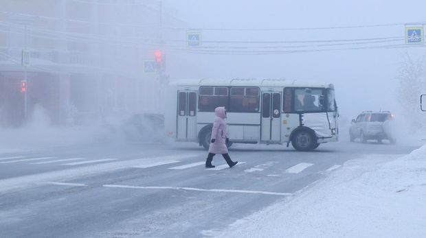 A pedestrian crosses a road on a frosty day in Yakutsk, Russia, January 15, 2023. Yakutsk, one of the Russia's north-most cities, is hit by an extreme cold snap as the air temperature on Sunday (January 15) plunged as low as minus 51 degrees Celsius (minus 59.8 degrees Fahrenheit). REUTERS/Roman Kutukov