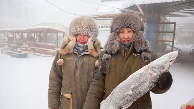 Fish vendors Marina Krivolutskaya and Marianna Ugai pose for a picture at an open-air market on a frosty day in Yakutsk, Russia, January 15, 2023. Yakutsk, one of the Russia's north-most cities, is hit by an extreme cold snap as the air temperature on Sunday (January 15) plunged as low as minus 51 degrees Celsius (minus 59.8 degrees Fahrenheit). REUTERS/Roman Kutukov