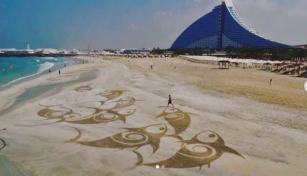 Seniman Filipina yang berbasis di Dubai, Nathaniel Alapide, memperlihatkan kemampuannya menjadikan garis pantai Dubai sepanjang 72 Km sebagai kanvas lukisannya. (Nathaniel Alapide/Instagram)