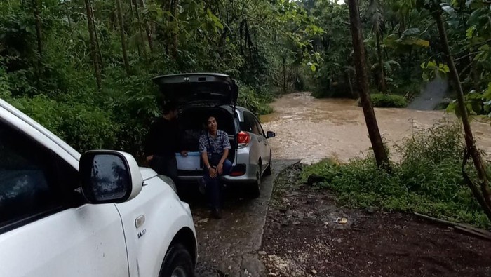 Warga menunggu air surut pada Rabu (18/1/2023) agar bisa melewati Sungai Bojong Pangandaran yang tak memiliki jembatan.