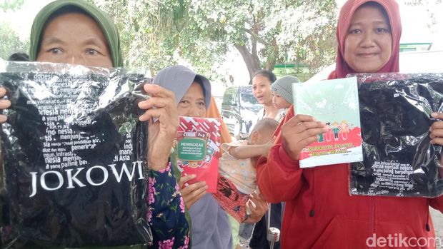 Warga menunjukkan kaus dan buku yang dibagikan Iriana Jokowi di Polanharjo, Klaten, Rabu (18/1/2023).