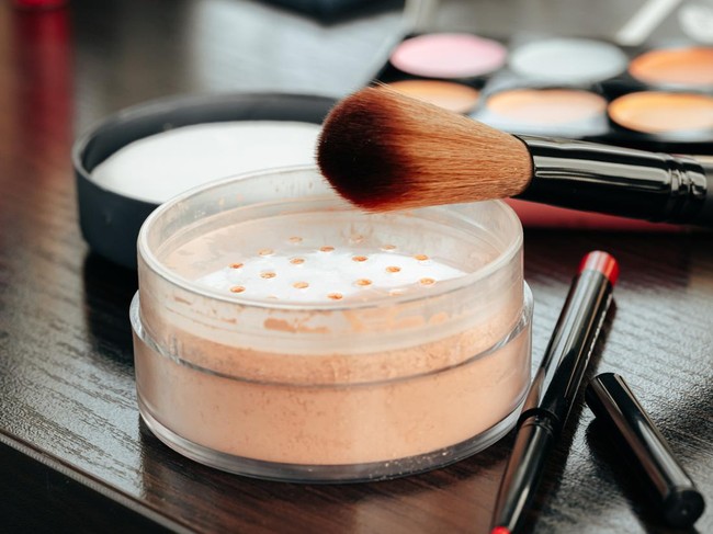 Open loose powder container on table close up photo
