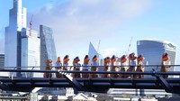 Sekelompok orang mengenakan kostum dinosaurus dengan berjalan di atas Millennium Bridge, London, Inggris, Rabu (18/1/2023).  