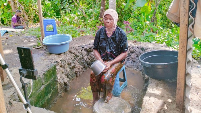 Layar Sari alias Inak Mawar (55) asal Dusun Pedek Setanggor Timur 2, Desa Setanggor, Lombok Tengah, saat sedang live TikTok dengan adegan mandi lumpur, Kamis (19/1/2023) siang. (Foto: Ahmad Viqi/detikBali)