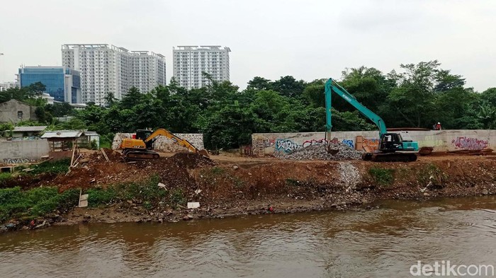 Pekerja menggunakan alat berat menyelesaikan proyek normalisasi Sungai Ciliwung di kawasan Cawang, Jakarta, Kamis (19/1/2023). Pemerintah Provinsi DKI Jakarta menganggarkan biaya sebesar Rp 469,29 miliar untuk program normalisasi Sungai Ciliwung pada APBD 2023. Tercatat saat ini pekerjaan normalisasi Sungai Ciliwung sudah mencapai 16 kilometer dari 33 kilometer rencana panjang tanggul yang akan dibangun.