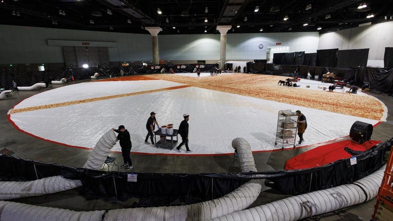Cooks work inside the Los Angels Convention center as Pizza Hut attempts to create the World's largest pizza of 14,101 square feet in Los Angeles, California, U.S., January 18, 2023.   REUTERS/Mike Blake