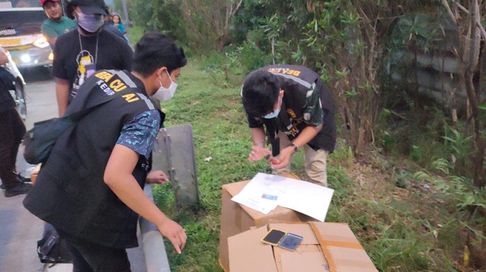 Petugas menggeledah dus yang berisi ribuan batang rokok ilegal yang dikirim melalui bus