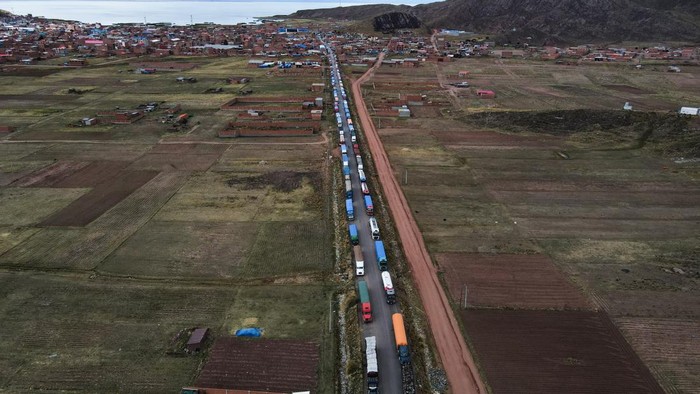 DESAGUADERO, BOLIVIA - PERU BORDER - JANUARY 18: An aerial view of dozens of Bolivian trucks that were stranded by blockades in the Peruvian sector in Desaguadero, Bolivia, Peru Border on January 18, 2023. The current situation in Peru, where social sectors demand the resignation of the Peruvian president, affected Bolivia in a blockade in the border sector of Desaguadero, a border that unites Peru and Bolivia. (Photo by Luis Gandarillas/Anadolu Agency via Getty Images)